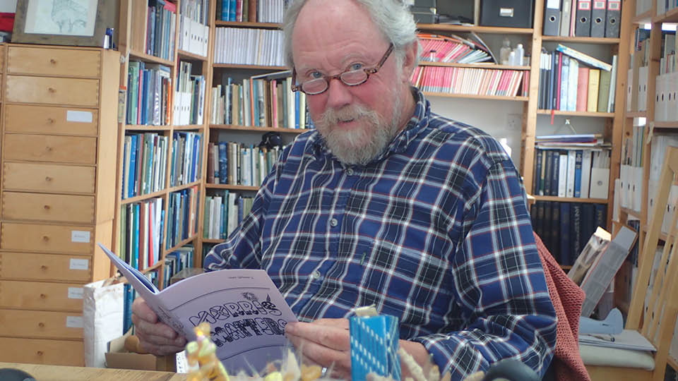 bearded man surrounded by books